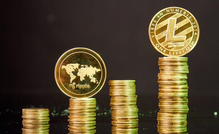 Stacks of litecoins and ripple coins on dark background.